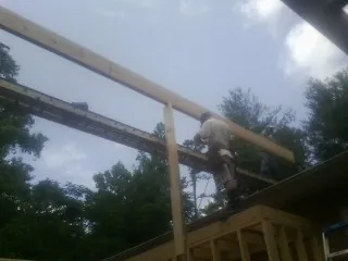 Carpenter setting a ridge beam over a new addition frame — Ice Dam Removal by Roofing Brothers in Horsham