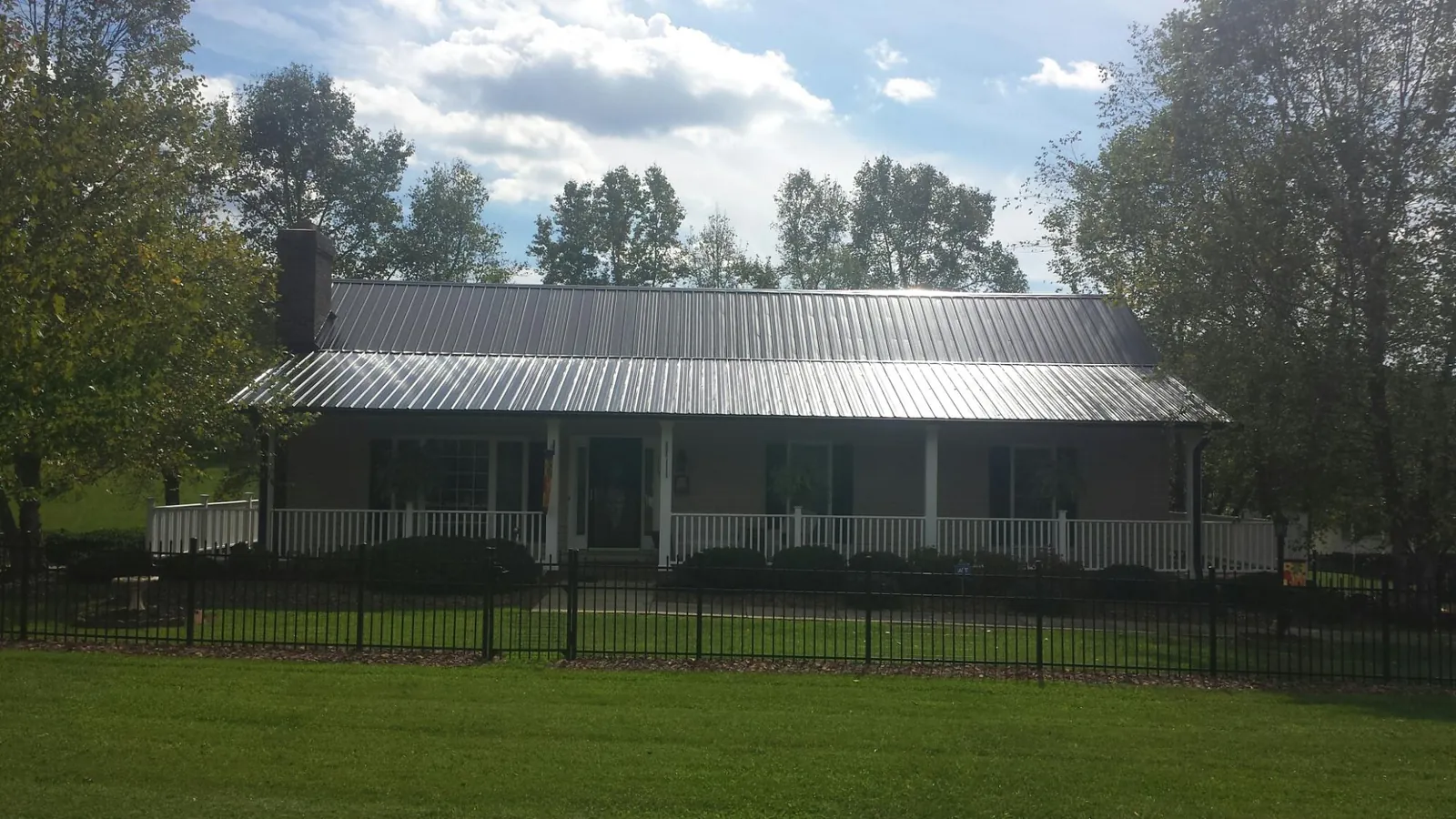 Gray metal roof on a brick ranch with a full width front porch — Gutter Guard Installation work by our crew in Horsham